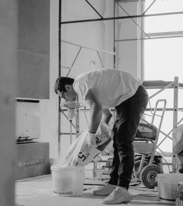 pexels-photo-6474294-6474294 A construction worker pours materials inside a building under renovation.